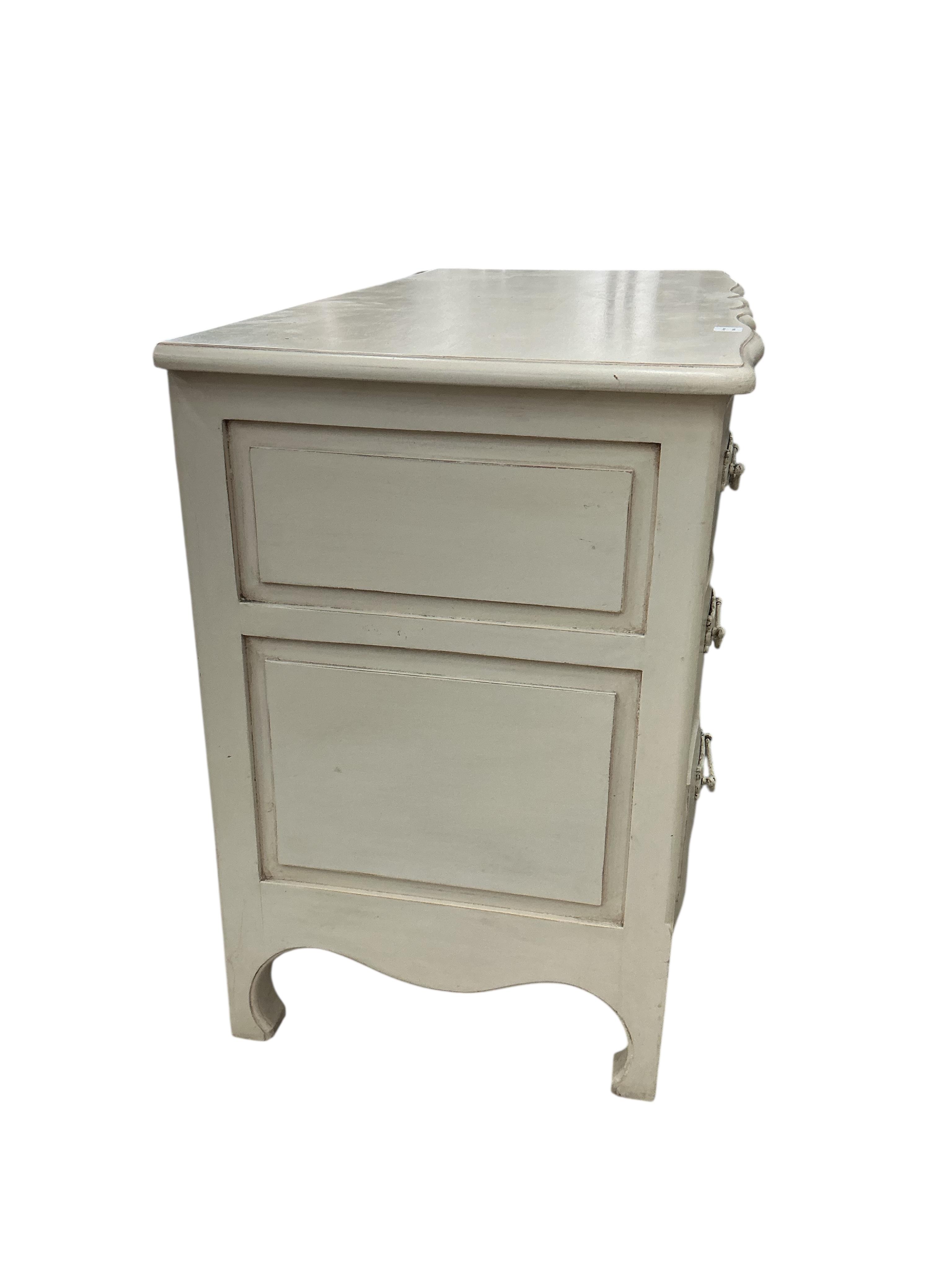 An 18th century style cream painted three drawer commode, width 126cm, depth 61cm, height 90cm, Provenance: The late Kenneth Turner (1936-2025), celebrity florist, designer and perfume retailer, he received the Royal War